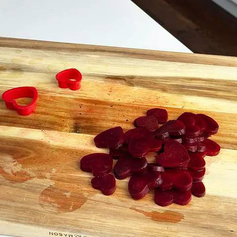 beets cut into heart shapes on a  cutting board.