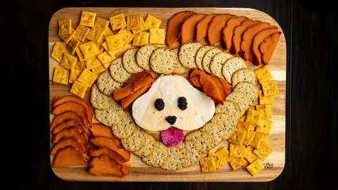 a vegan charcuterie board with a cheese dog in the middle.