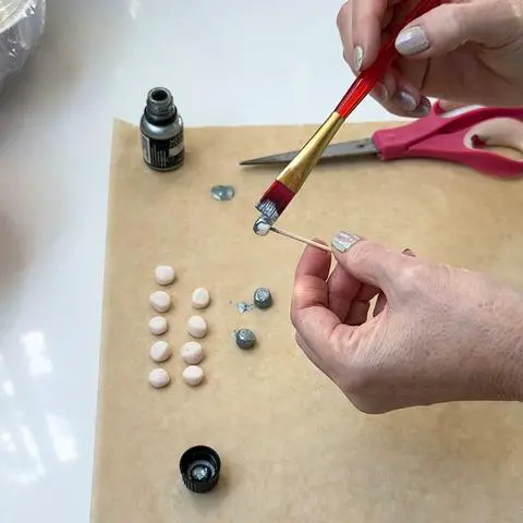 painting the cut marshmallows with edible silver paint.