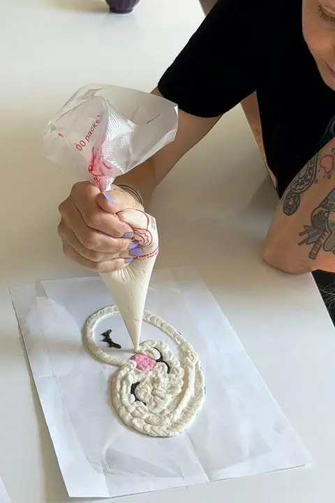 piping the white frosting for the reindeer face.