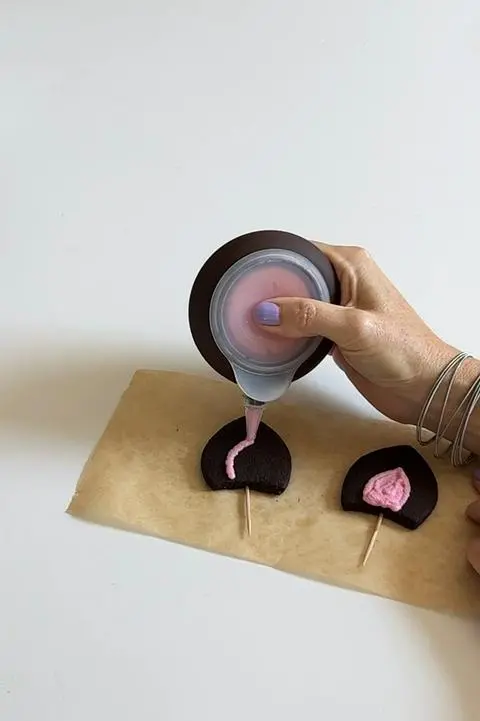 Coloring in the ears with pink buttercream frosting.