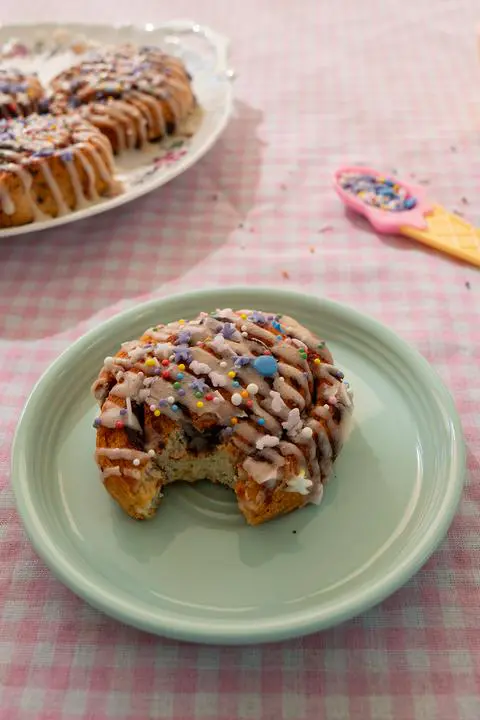 cinnamon roll on a plate with a bite missing.