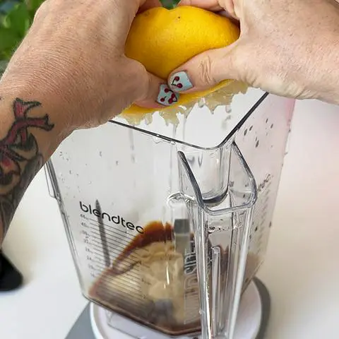 squeezing lemon juice into the blender.