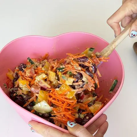 mixing the tahini dressing into the couscous salad.