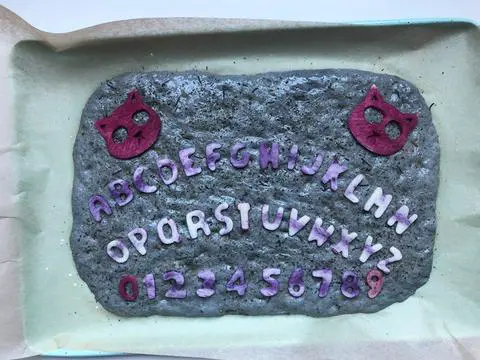 vegan focaccia decorated with ouija board halloween focaccia art
