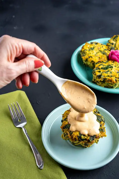 pouring sauce over the mini vegan gluten-free frittata.