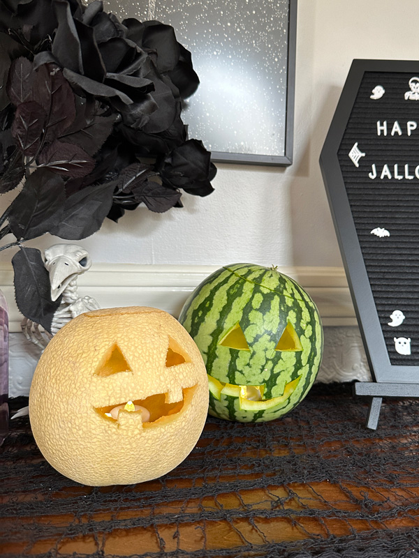 a watermelon and another melon carved into jack-o-lanterns.