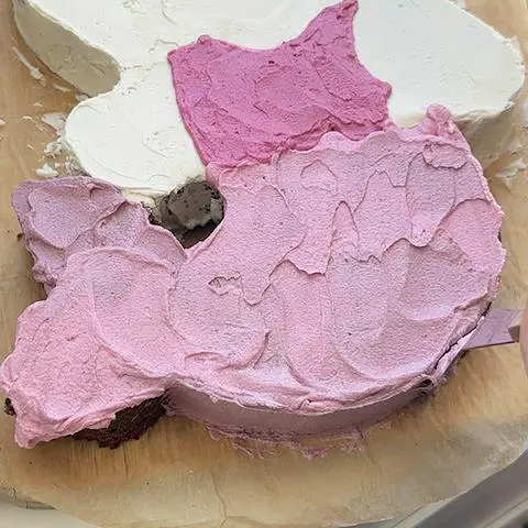 frosting the sides of the cake where the mermaid tail is.