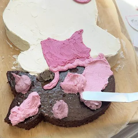 using an offset spatula to smooth out the frosting on the mermaid tail.