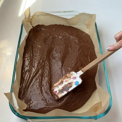 spreading the cake batter with a spatula to make it smooth and flat on top.
