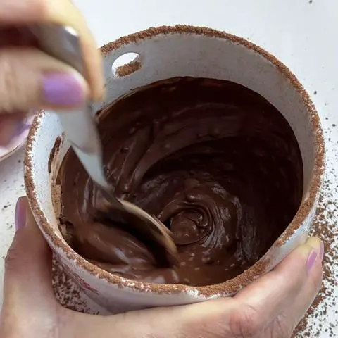 continuing to stir the coffee and cocoa powder.