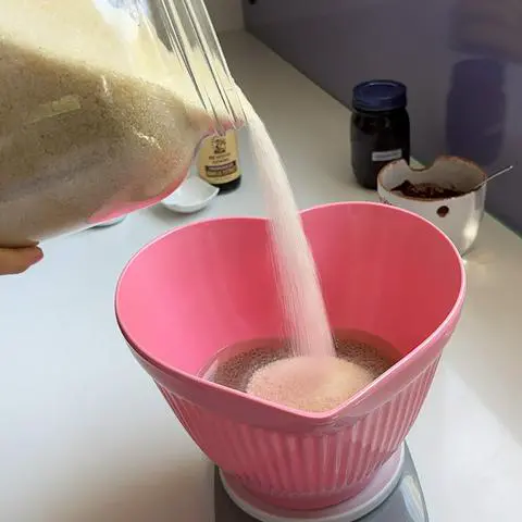 adding sugar to the bowl of wet ingredients.