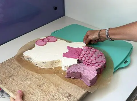 moving the hello kitty cake onto the cake carrier.