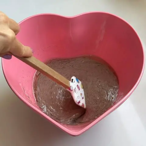 stirring the wet ingredients in a heart shaped bowl.
