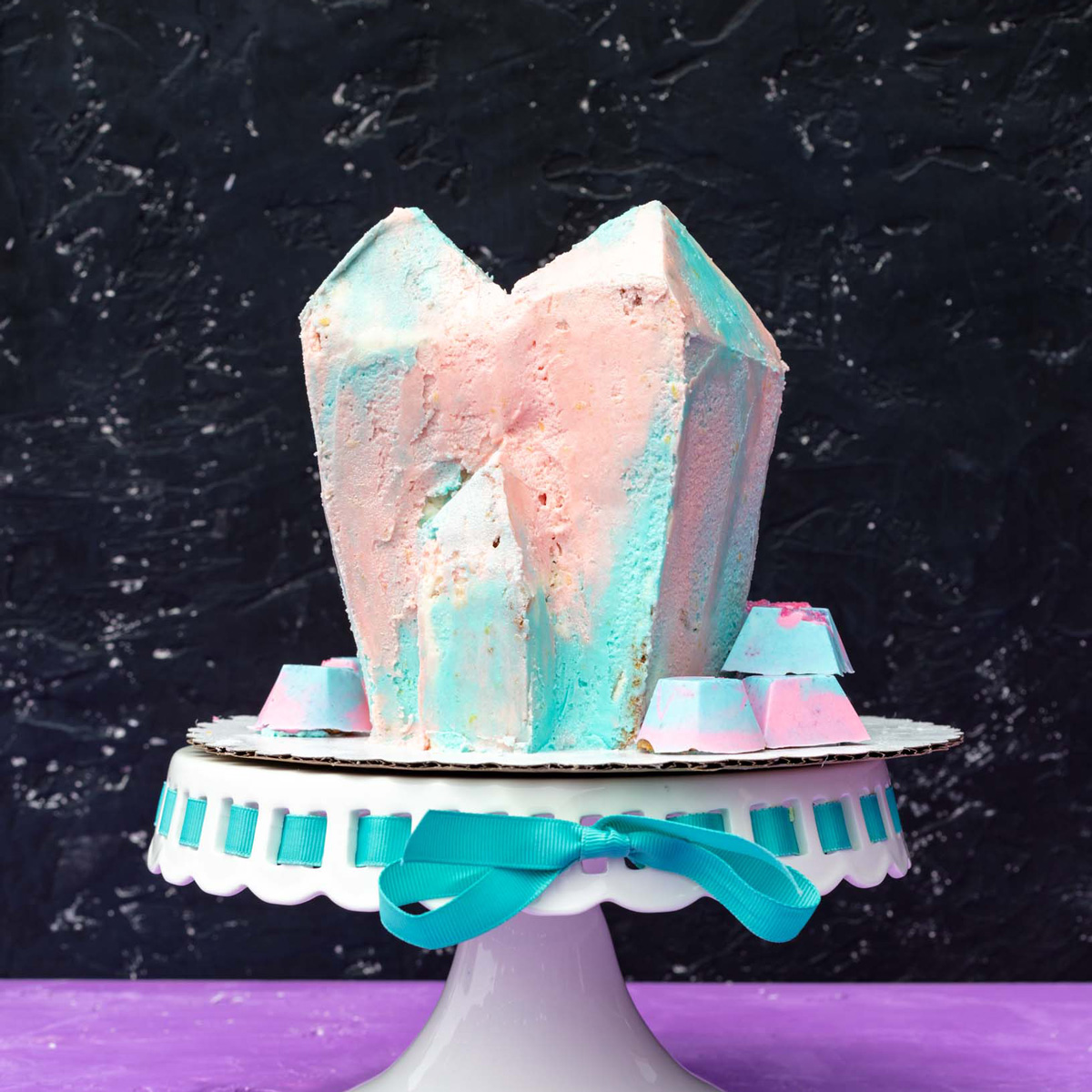 loquat cake that is shaped into a crystal formation and decorated with pastel blue and pink frosting