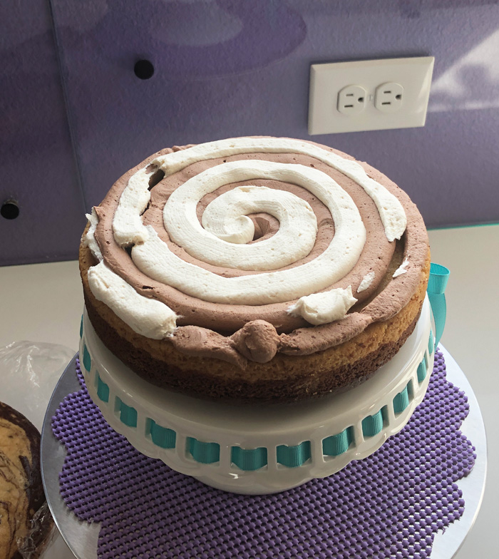 vegan vanilla and chocolate frosting swirled between the 2 layers of marble cake