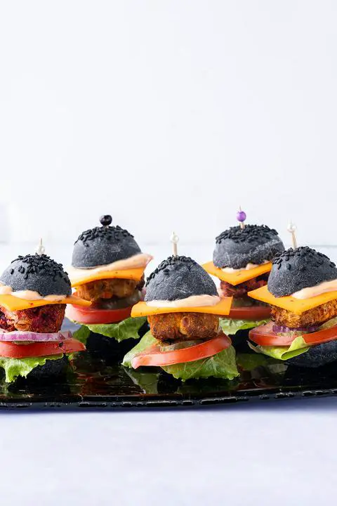 lots of baby veggie slides on a plate with toothpicks in them.