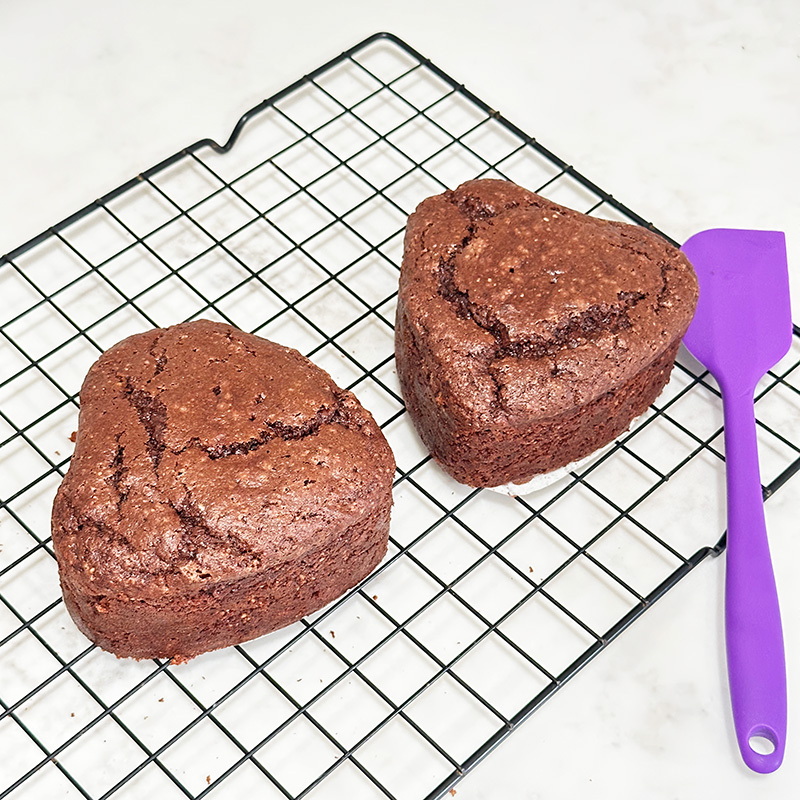 Chocolate mini heart cakes on a cooling rack.