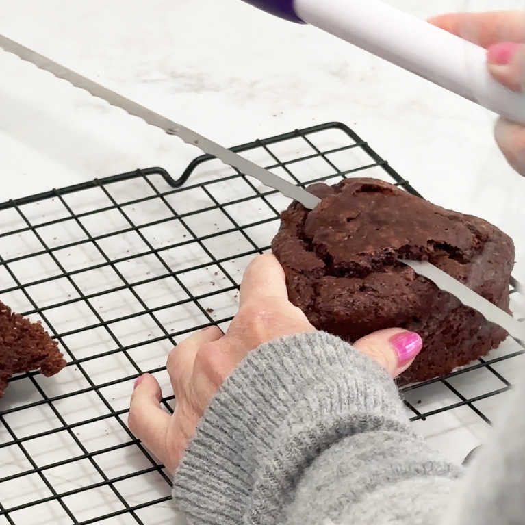 Cutting the top off of one of the heart cakes.