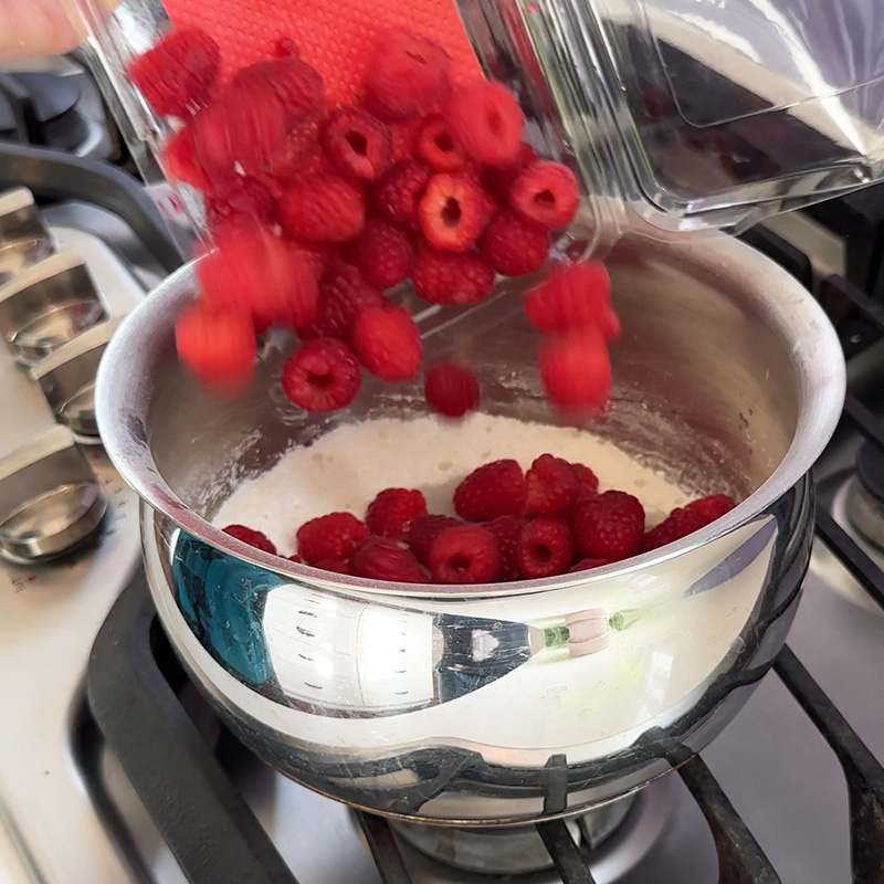 Adding raspberries to saucepan.