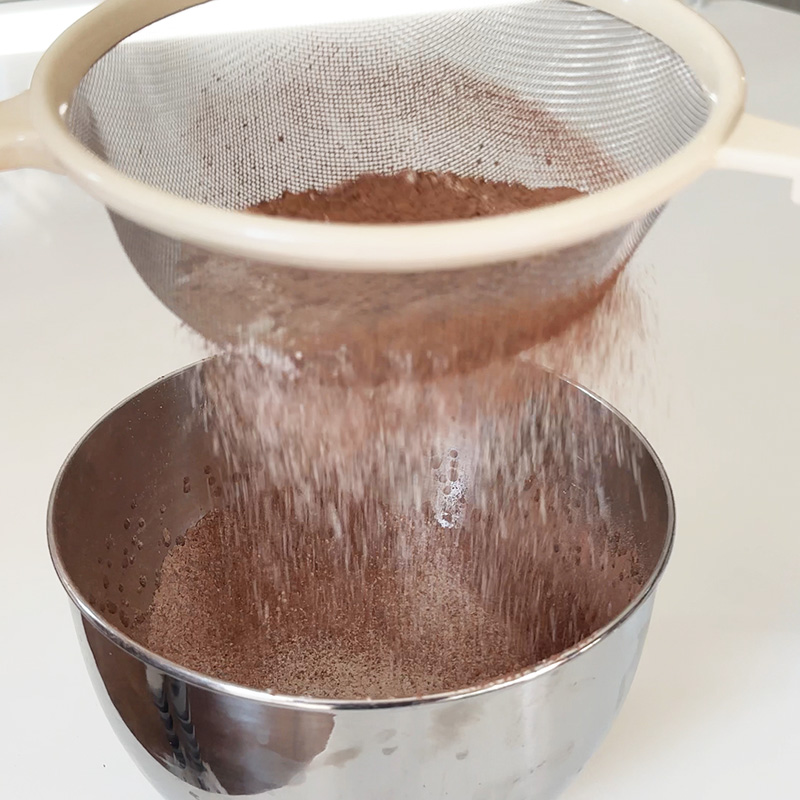 Sifting the dry ingredients into the mixing bowl.