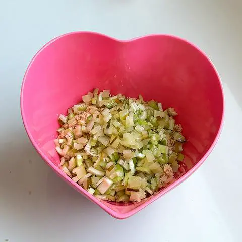 pink heart bowl with vegan tuna, celery, and pickle.