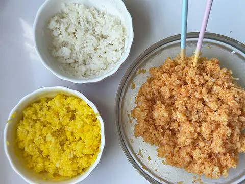 3 bowls of cooked and colored sushi rice: one white, one yellow, and one orange.