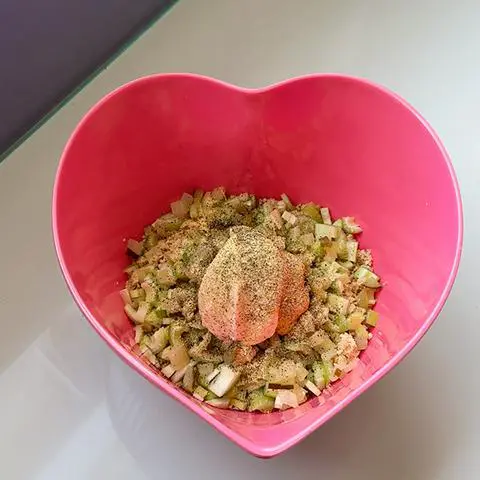 pink heart bowl with vegan tuna, celery, pickle, vegan mayo, mustard, and spices.