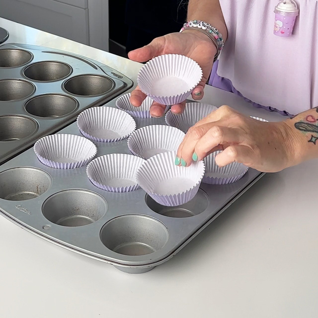 lining a cupcake pan with cupcake papers.