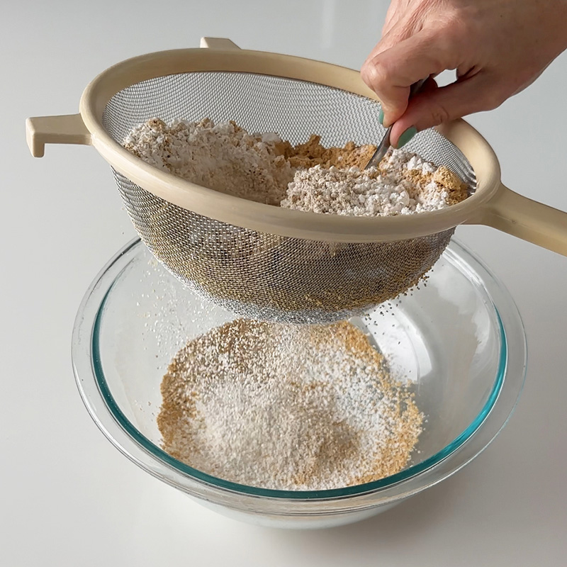 sifting peanut butter powder and powdered sugar.