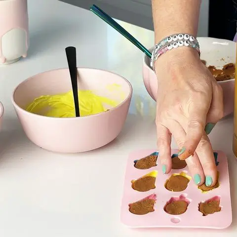 pressing the ball of peanut butter filling into the chocolate molds.