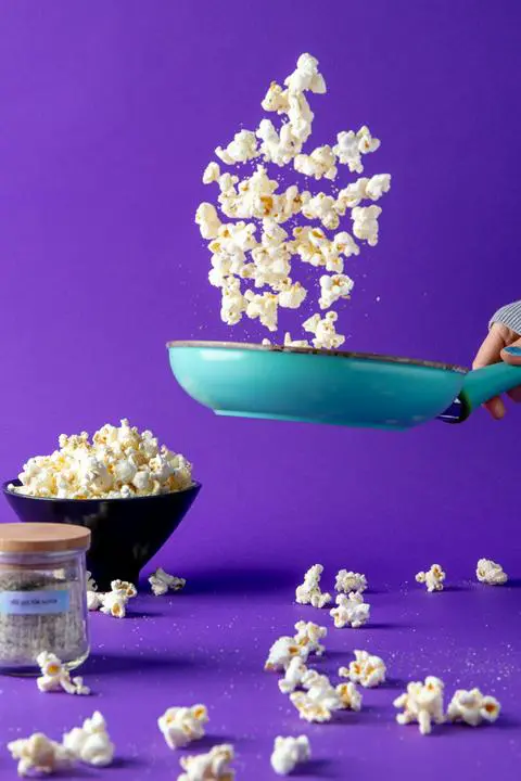 flipping dill pickle popcorn and dill pickle seasoning in a pan