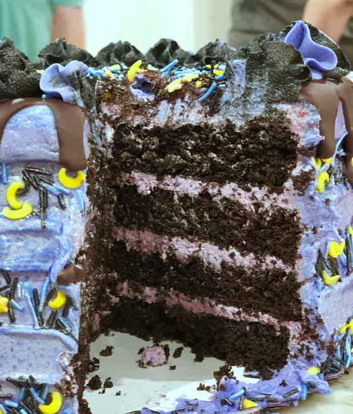 cutting the vegan chocolate blackberry halloween cake