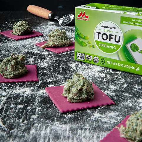 making spinach ravioli with pink beet colored vegan ravioli dough