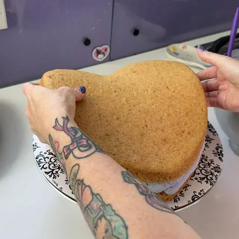 placing the second layer of cake on top of the blueberry filling layer.
