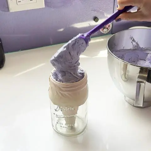 filling a piping bag with frosting.