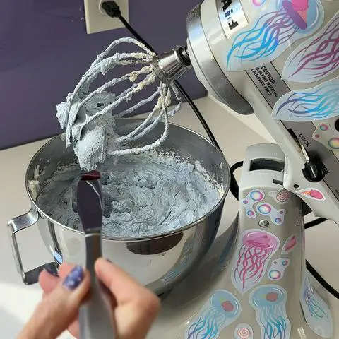 adding pink gel color to light blueish frosting.