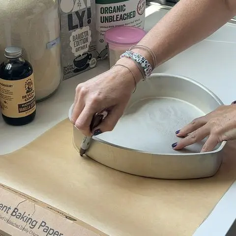 tracing the shape of a cake pan onto parchment paper with a sharpie.