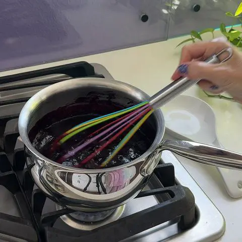 whisking the blueberry filling on the stove.